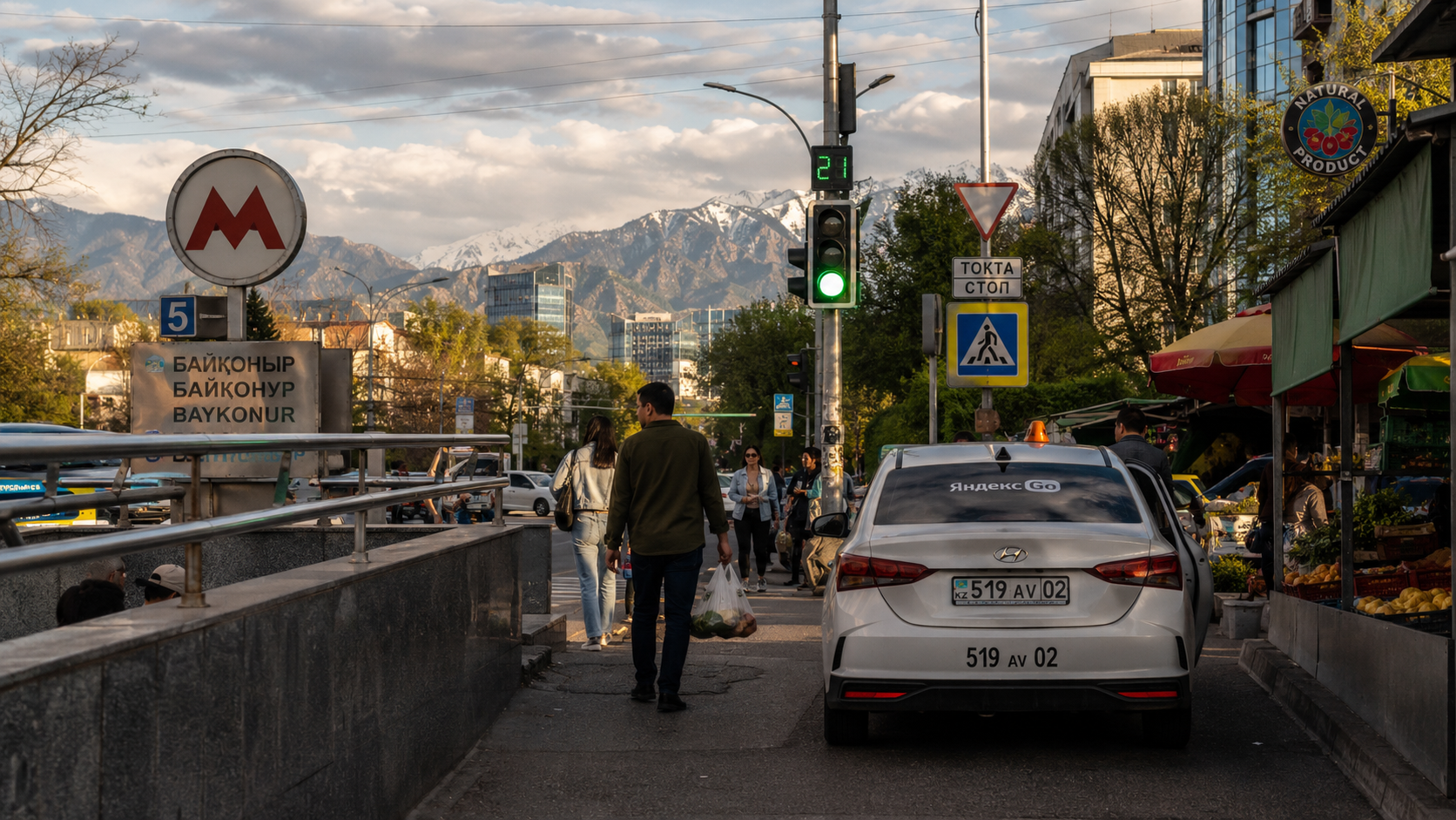 Almaty travel guide: Almaty street corner with transport, pedestrians, and mountain light.