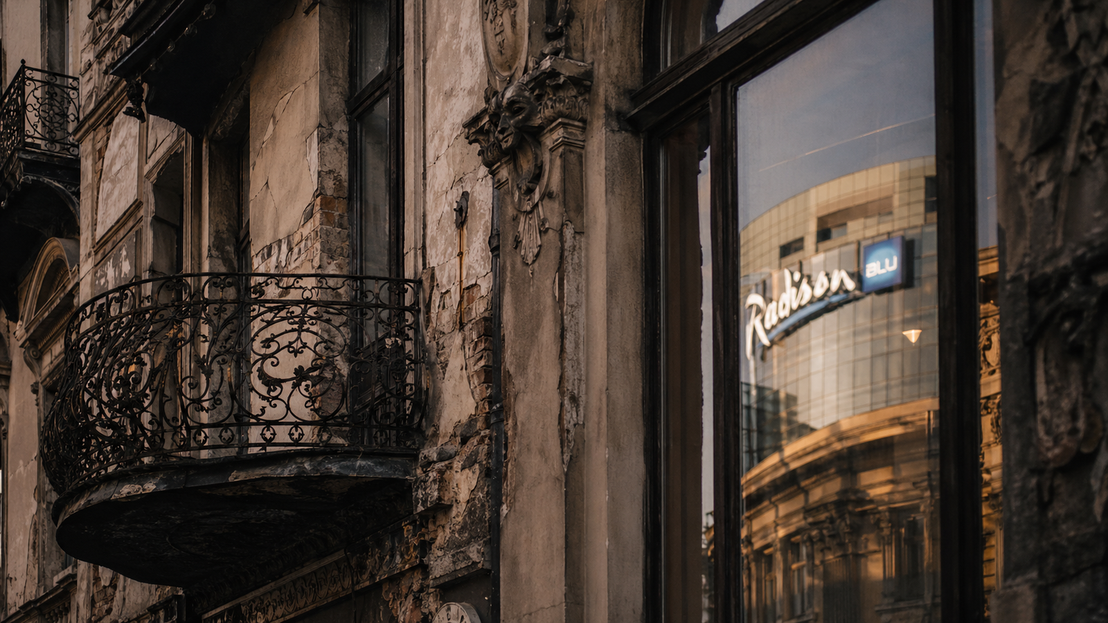 Close-up of Bucharest architectural contrasts with ornate balcony and worn urban texture.