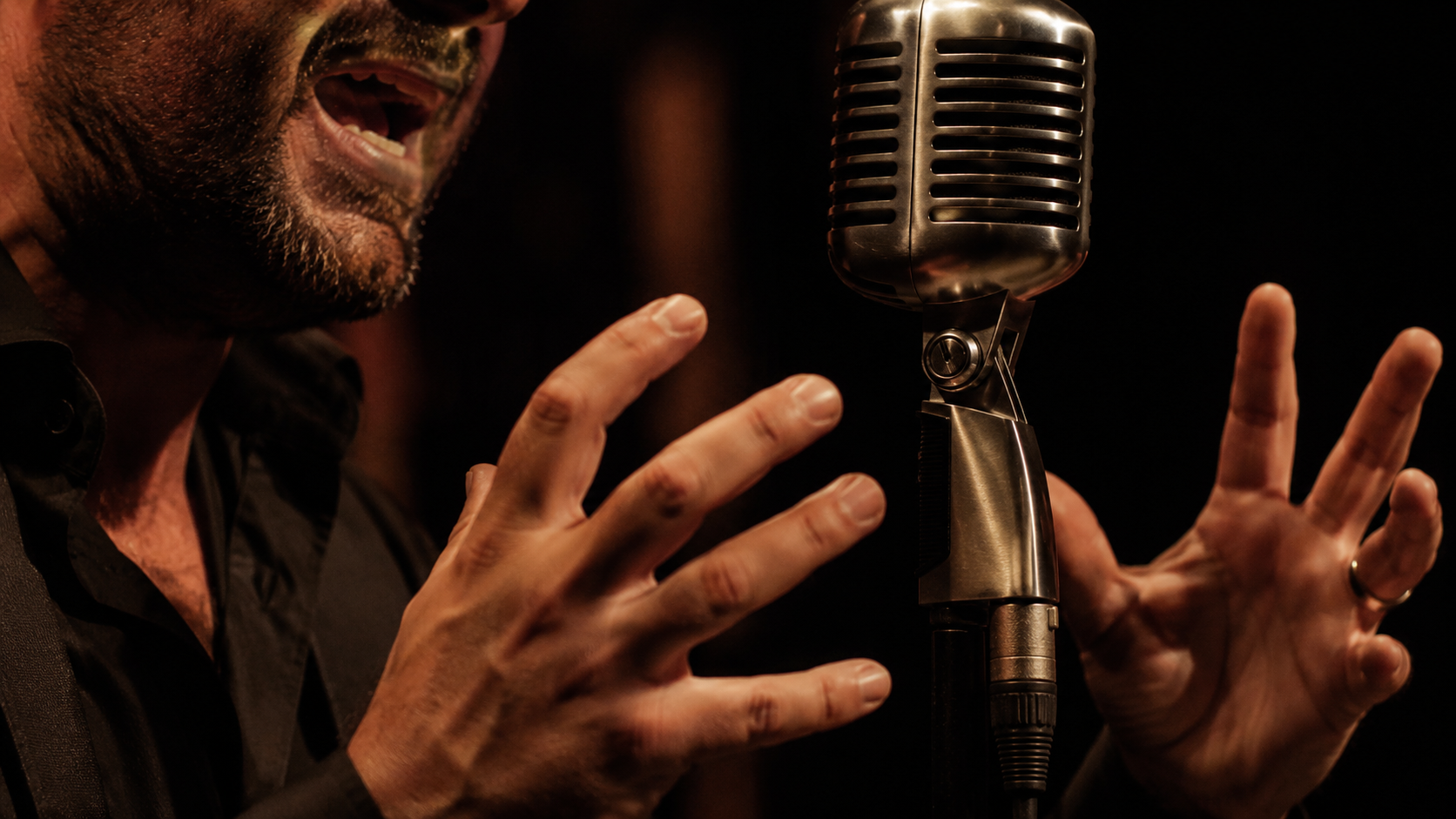 Close-up of a flamenco singer performing cante at a microphone.