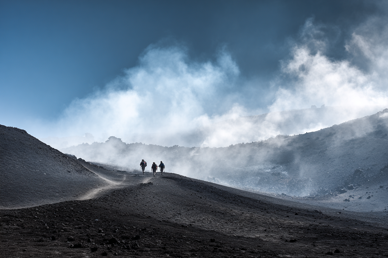 Hikers trekking on the volcanic landscape of Mount Etna in Sicily, a unique Italy outdoor adventure.