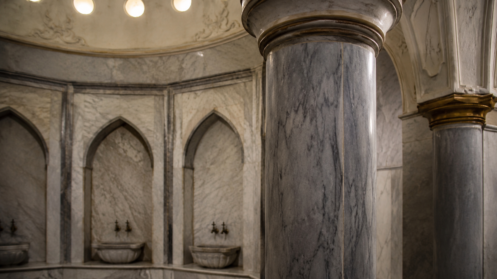 Turkish hamam architecture with marble columns, arched niches, basins, and steam