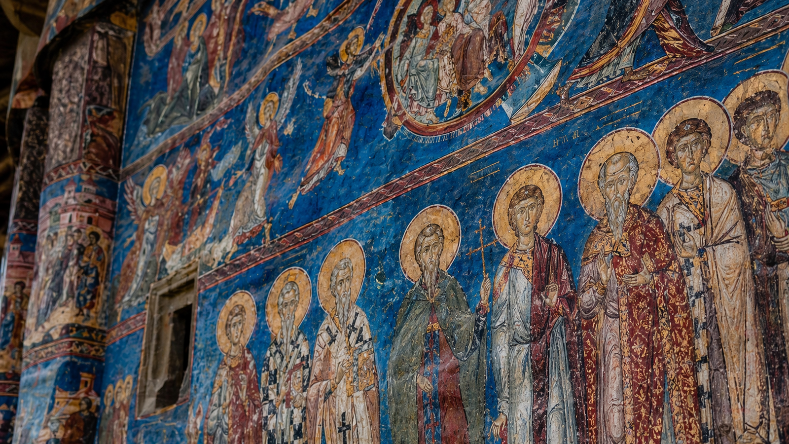 Deep blue exterior frescoes in the style of Voronet Monastery.