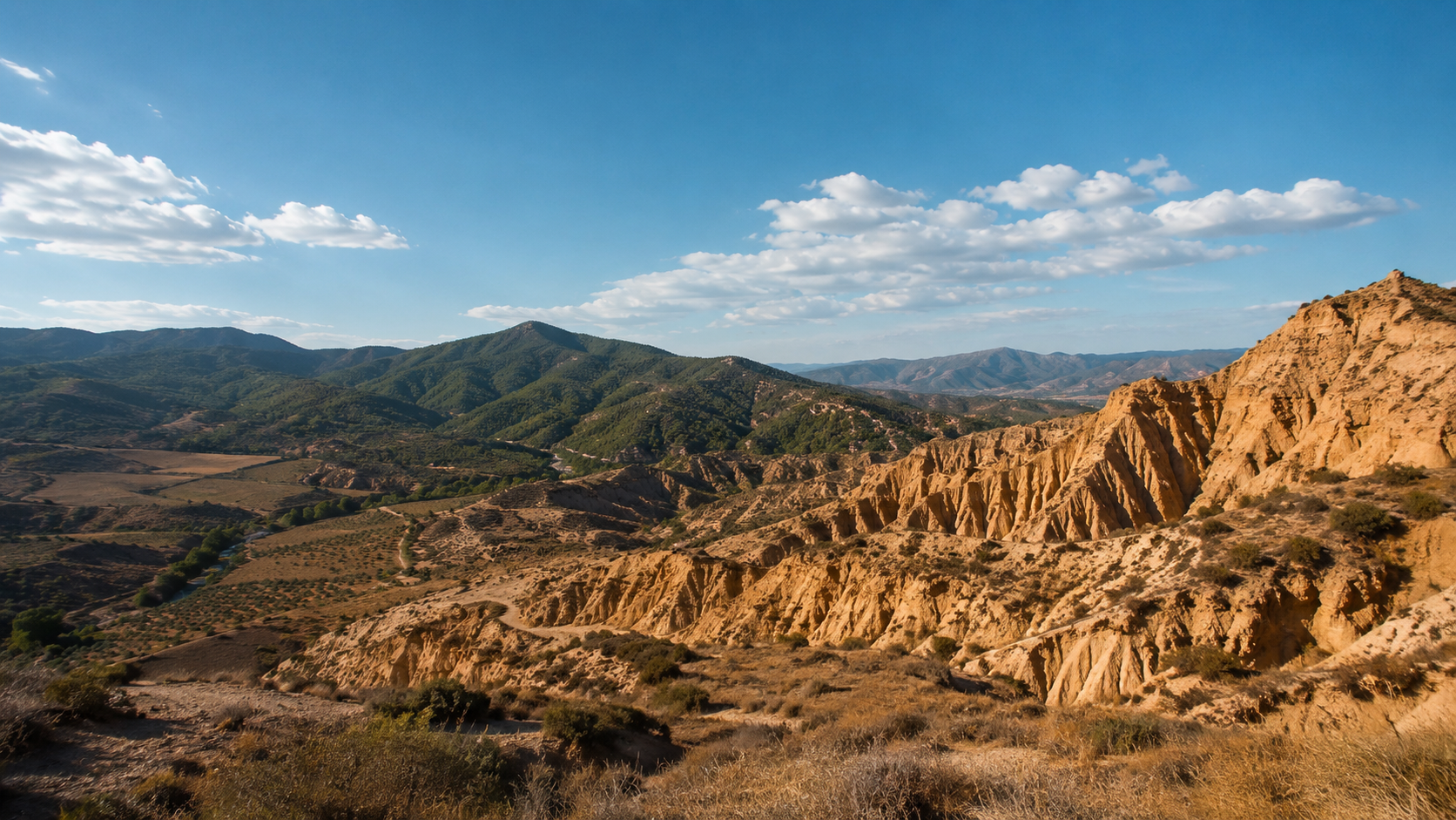 Contrasting Spanish terrain with dry hills and distant green mountains.