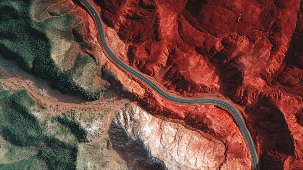 Aerial road weaving through diverse Australian landscapes.